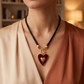 Collar de Cordón Negro con Dije de Corazón Dorado y Fondo Rojo
