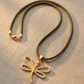 Collar Nerea de Cordón Náutico Verde con Dije de Esqueleto de Pez en Oro Mate