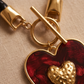Collar de Cordón Negro con Dije de Corazón Dorado y Fondo Rojo