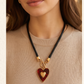 Collar de Cordón Negro con Dije de Corazón Dorado y Fondo Rojo