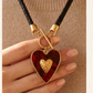 Collar de Cordón Negro con Dije de Corazón Dorado y Fondo Rojo
